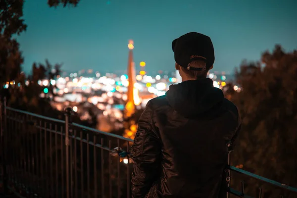Vista Trasera Hombre Con Abrigo Gorra Mirando Ciudad Por Noche —  Fotos de Stock