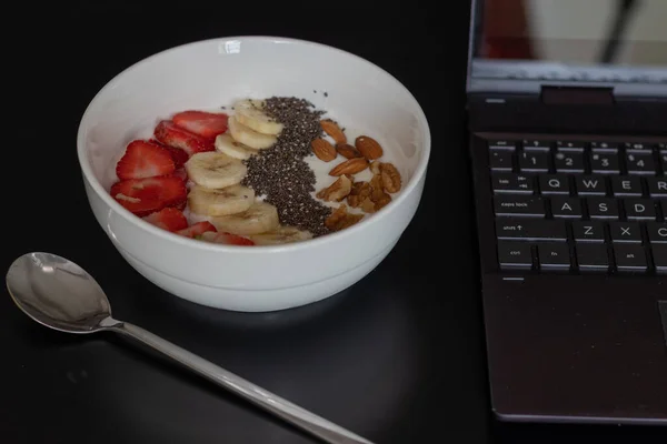 Primer Plano Tazón Yogur Con Frutas Mesa Con Una Computadora — Foto de Stock