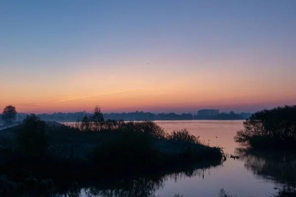 Красивый Снимок Силуэтов Деревьев Озере Красочным Закатным Небом — стоковое фото
