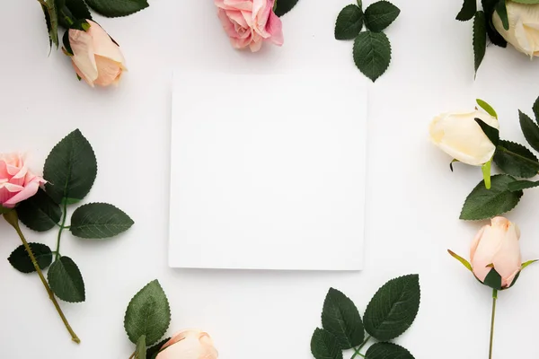 Uma Vista Superior Rosas Torno Pedaço Quadrado Papel Branco Isolado — Fotografia de Stock