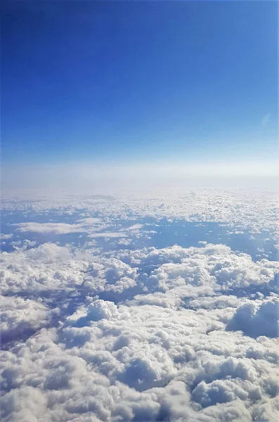 明るい空の下で飛行機から見た地球と白い雲の美しい景色 — ストック写真