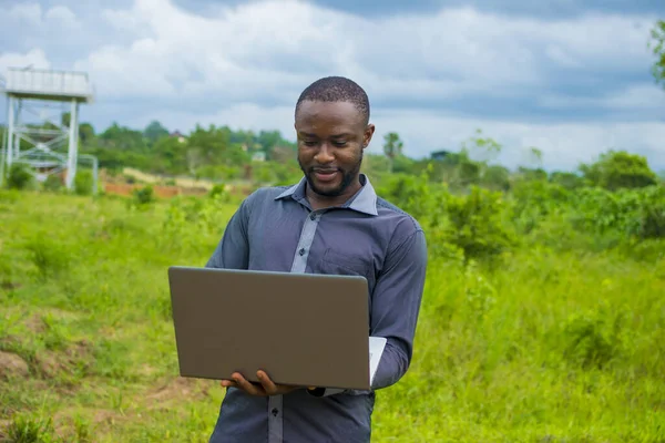 Ein Junger Afrikanischer Mann Steht Draußen Und Benutzt Einen Laptop — Stockfoto