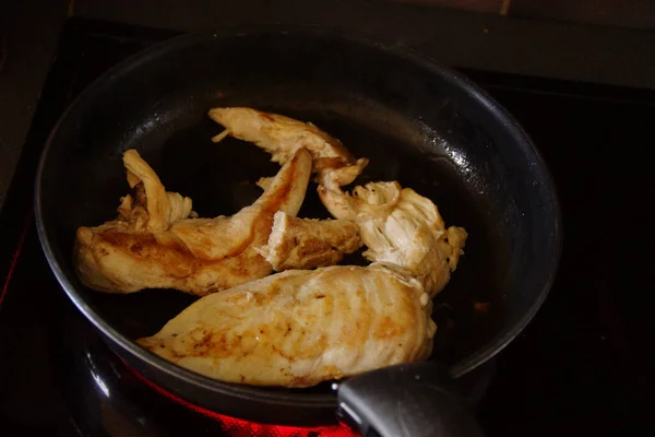 在一个深色的煎锅上拍了一张特写的鸡肉片 — 图库照片