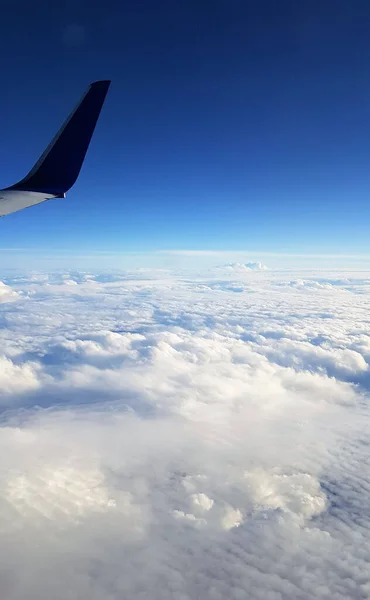 白いふわふわの雲の上を飛ぶ飛行機の翼の美しい景色 — ストック写真