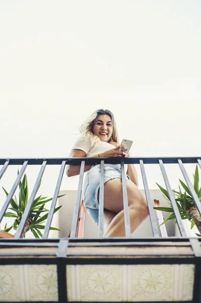 Genç Bir Spanyol Kadının Telefonunu Kullanarak Bir Apartmanın Balkonundan Aşağıya — Stok fotoğraf