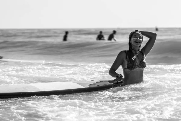 カディスの波状の海でサーフィンしている白人女性のグレースケールショット — ストック写真