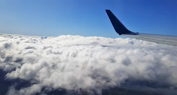 白いふわふわの雲の上を飛ぶ飛行機の翼の美しい景色 — ストック写真