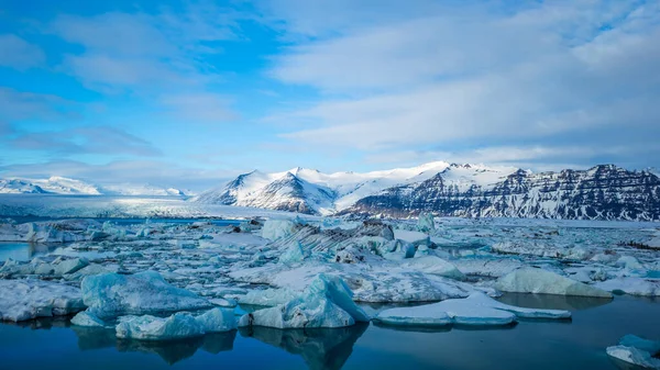 アイスランドの太陽の下で氷に覆われた丘や湖の風景 — ストック写真