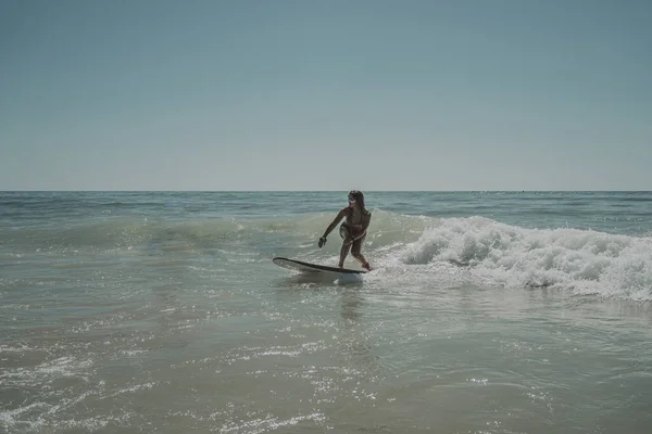 波浪の海でサーフィンする白人女性 — ストック写真