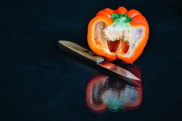 Μισό Κόκκινο Βουλγαρικό Πιπέρι Και Ένα Μαχαίρι Αντανακλάται Στο Έδαφος — Φωτογραφία Αρχείου