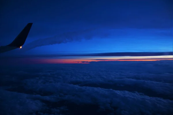 日落时分一架飞机在白云上空飞行的美丽照片 — 图库照片