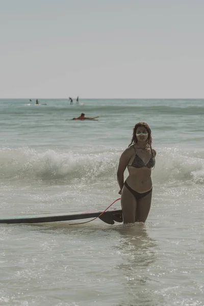 Een Verticaal Schot Van Een Mooie Jongedame Met Een Surfplank — Stockfoto