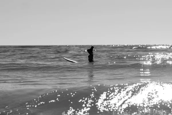 Μια Γκρίζα Φωτογραφία Μιας Γυναίκας Που Σερφάρει Στα Κύματα Στο — Φωτογραφία Αρχείου