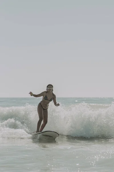 美しい若い女性のサーフィンの垂直ショット — ストック写真