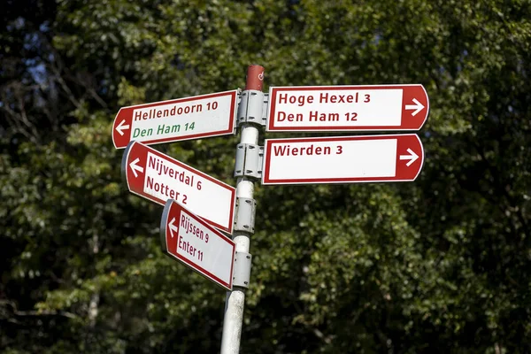 荷兰豪尔赫塞尔 2020年8月2日 荷兰自行车道上的标志与背景中的树叶形成了鲜明的对比 标志上有通往邻近城镇和村庄的方向和距离 — 图库照片