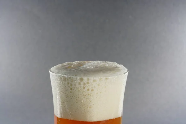 Gri Arka Planda Köpüklü Biranın Yakın Plan Çekimi — Stok fotoğraf