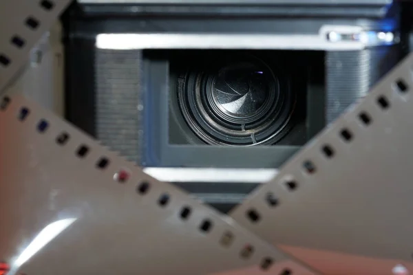 电影摄影机镜头的特写镜头 通过电影胶片的条纹框架可以看到 — 图库照片