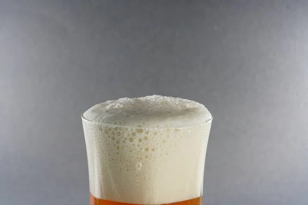 Gri Arka Planda Köpüklü Biranın Yakın Plan Çekimi — Stok fotoğraf