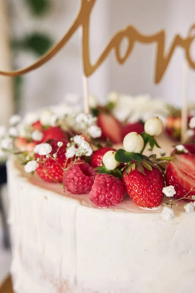 赤い果実 花やケーキのトッパーとおいしい白いウェディングケーキの選択的フォーカスショット — ストック写真