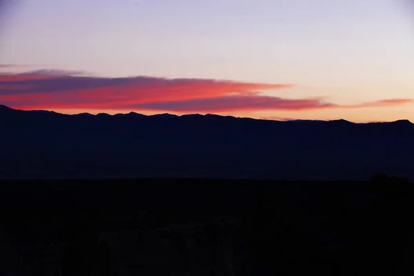 Tepelerin Siluetleri Üzerinde Güzel Bir Günbatımı Manzarası — Stok fotoğraf
