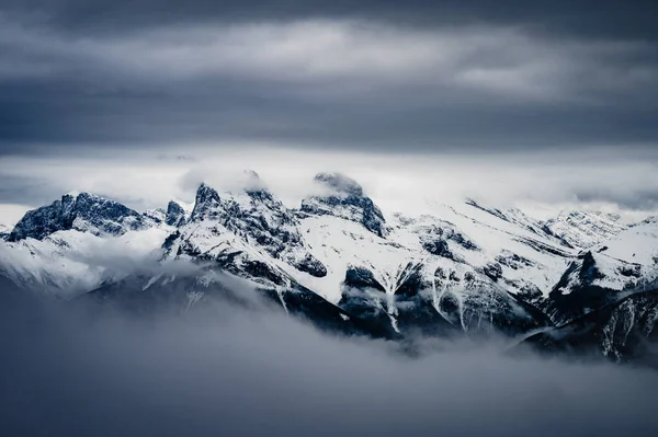 구름낀 바위투성이의 산들로 이루어진 눈덮인 봉우리들 — 스톡 사진