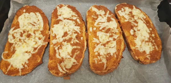 オーブンからチーズと一緒に焼きたてのトーストのオーバーヘッドショット — ストック写真