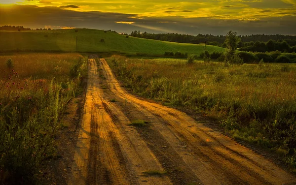 Belo Tiro Uma Estrada Através Campo Durante Pôr Sol Deslumbrante — Fotografia de Stock