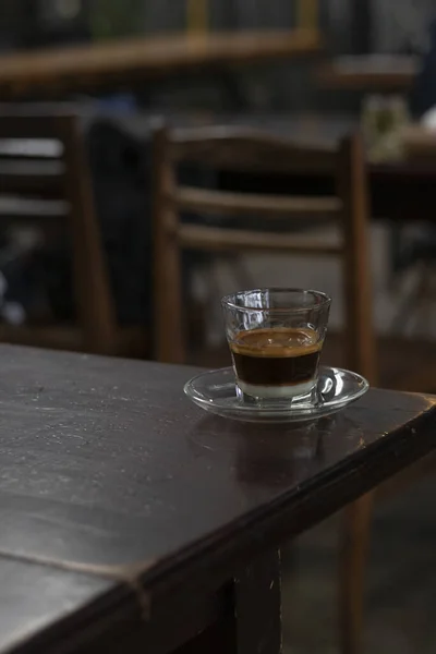 カフェのテーブルの上にプレートとエスプレッソのカップの垂直ショット — ストック写真