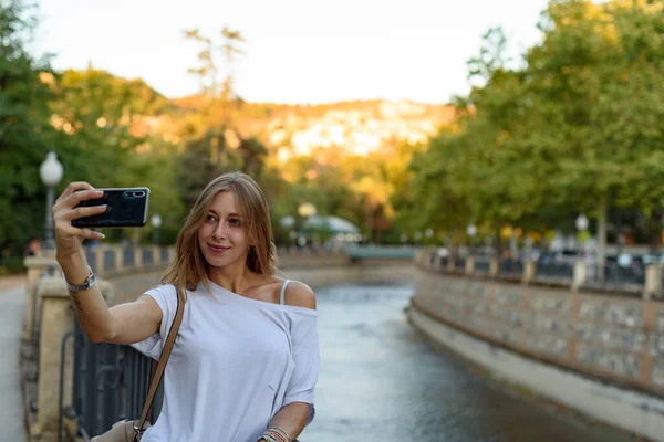 Ung Kvinna Som Står Bro Och Fotograferar Med Telefon — Stockfoto