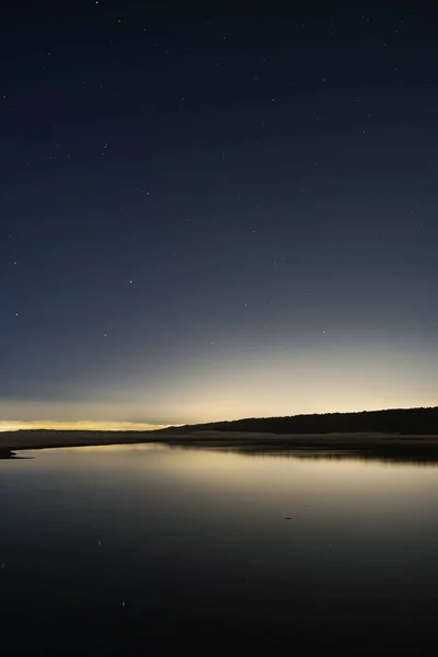 Eine Vertikale Aufnahme Eines Sonnenuntergangs Über Einem Ruhigen See — Stockfoto