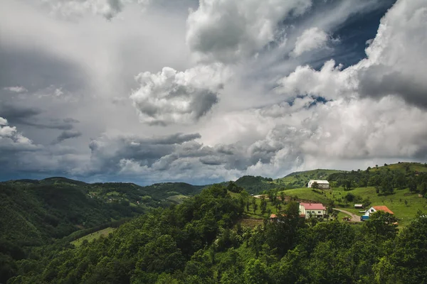 曇った空の背景に緑の山の風景の中に家の美しいショット — ストック写真