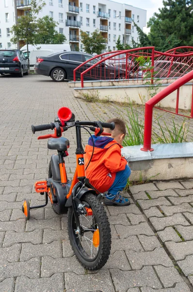 Giovane Ragazzo Cerca Qualcosa Accanto Una Piccola Bicicletta Città — Foto Stock