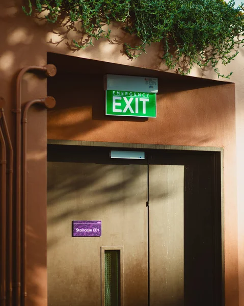 A green emergency exit sign above a door