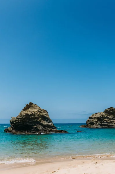 Tiro Vertical Oceano Com Duas Grandes Rochas Perto Costa Arenosa — Fotografia de Stock