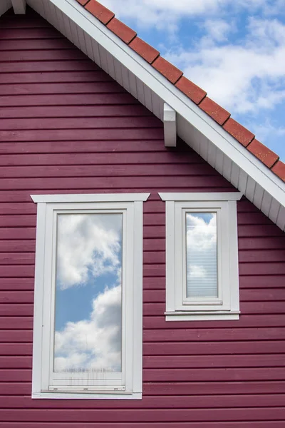 Vertikální Detailní Záběr Jasně Červeného Domu Kalným Odrazem Oblohy Okně — Stock fotografie