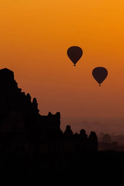 Donker Silhouet Van Twee Heteluchtballonnen Bij Zonsondergang Tegen Oranje Lucht — Stockfoto