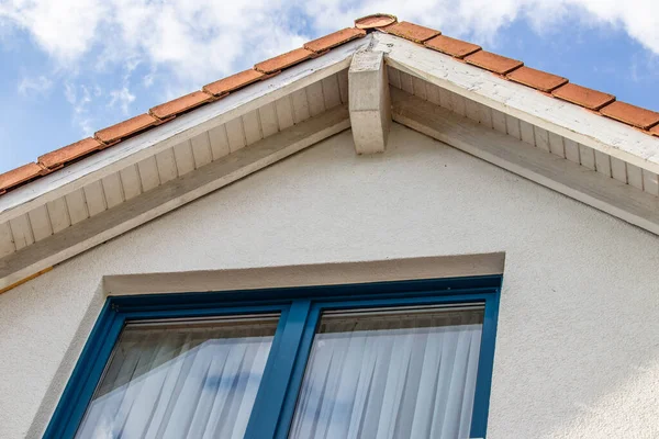 一种带有蓝色窗户的房屋屋顶的低角度照片 — 图库照片