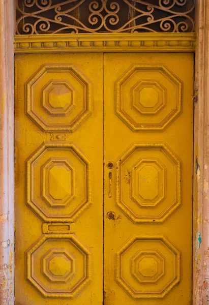 Вертикальный Снимок Старой Оранжевой Двери Древними Узорами — стоковое фото