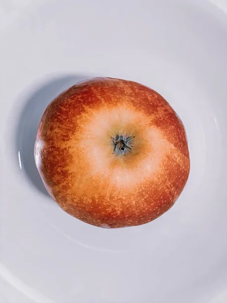 Beyaz Bir Yüzeyde Taze Bir Elmanın Dikey Yüksek Açılı Görüntüsü — Stok fotoğraf