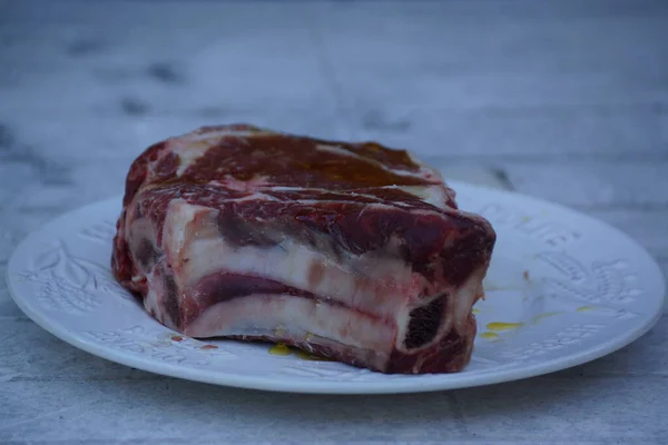 Egy Közeli Felvétel Nyers Sertéshúsból Steaknek Egy Tányéron — Stock Fotó