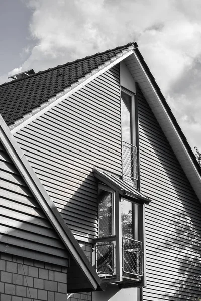 Eine Vertikale Graustufenaufnahme Der Fassade Eines Hauses Unter Bewölktem Himmel — Stockfoto