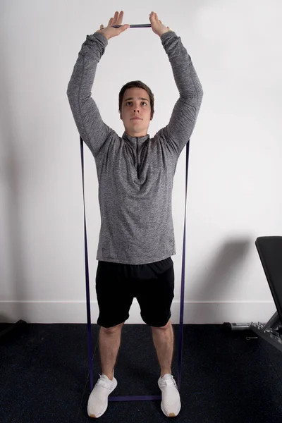 Una Toma Vertical Hombre Joven Forma Usando Una Banda Ejercicios —  Fotos de Stock