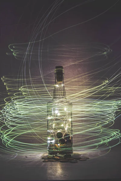 Disparo Vertical Una Botella Vidrio Llena Monedas Luces Cuerda — Foto de Stock