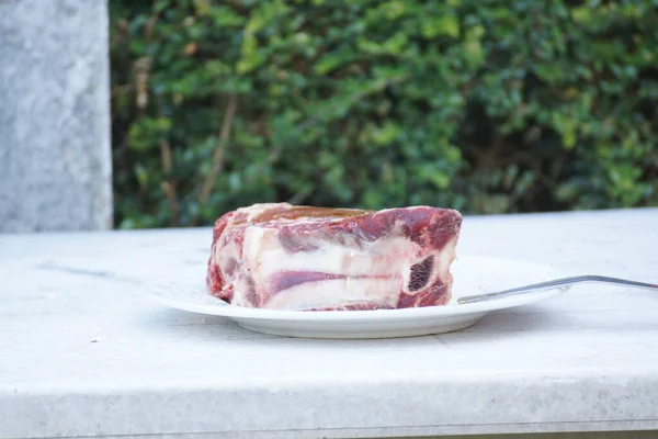 Egy Közeli Felvétel Nyers Sertéshúsból Steaknek Egy Tányéron — Stock Fotó