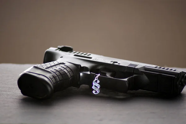 A closeup shot of a gun with the paragraph sign - gun control concept