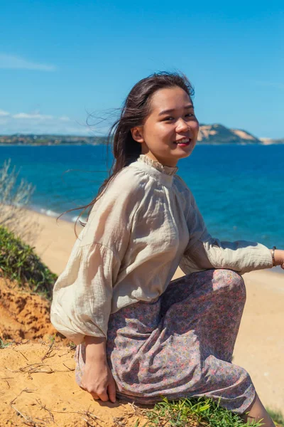Sahilde Gülümseyen Oturan Asyalı Genç Bir Kadının Dikey Görüntüsü — Stok fotoğraf