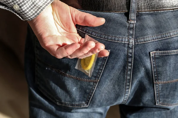 Een Hand Trekt Uit Het Pakje Van Een Condoom Uit — Stockfoto