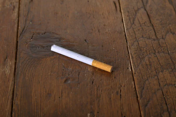 Primer Plano Cigarrillo Una Mesa Madera Bajo Las Luces —  Fotos de Stock