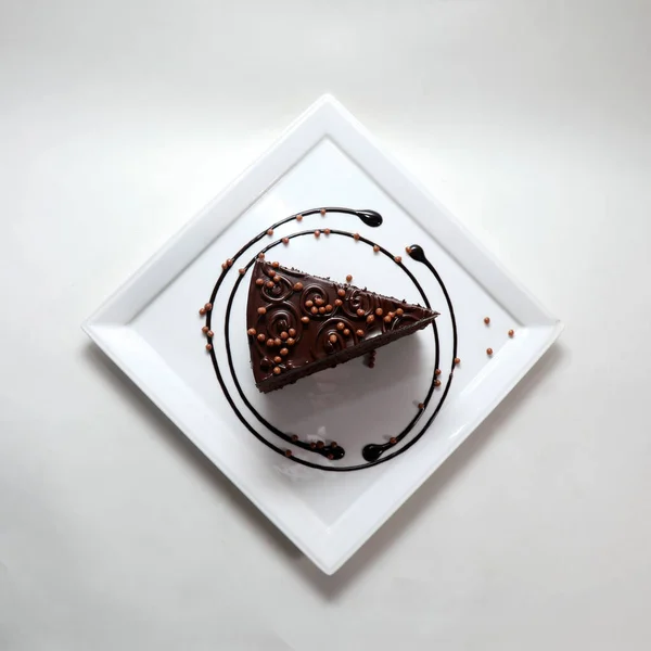 Uma Vista Superior Pedaço Bolo Chocolate Uma Placa Isolada Fundo — Fotografia de Stock