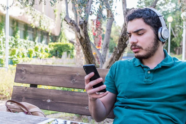 Hombre Caucásico Serio Sentado Usando Móvil Para Escuchar Música Con —  Fotos de Stock